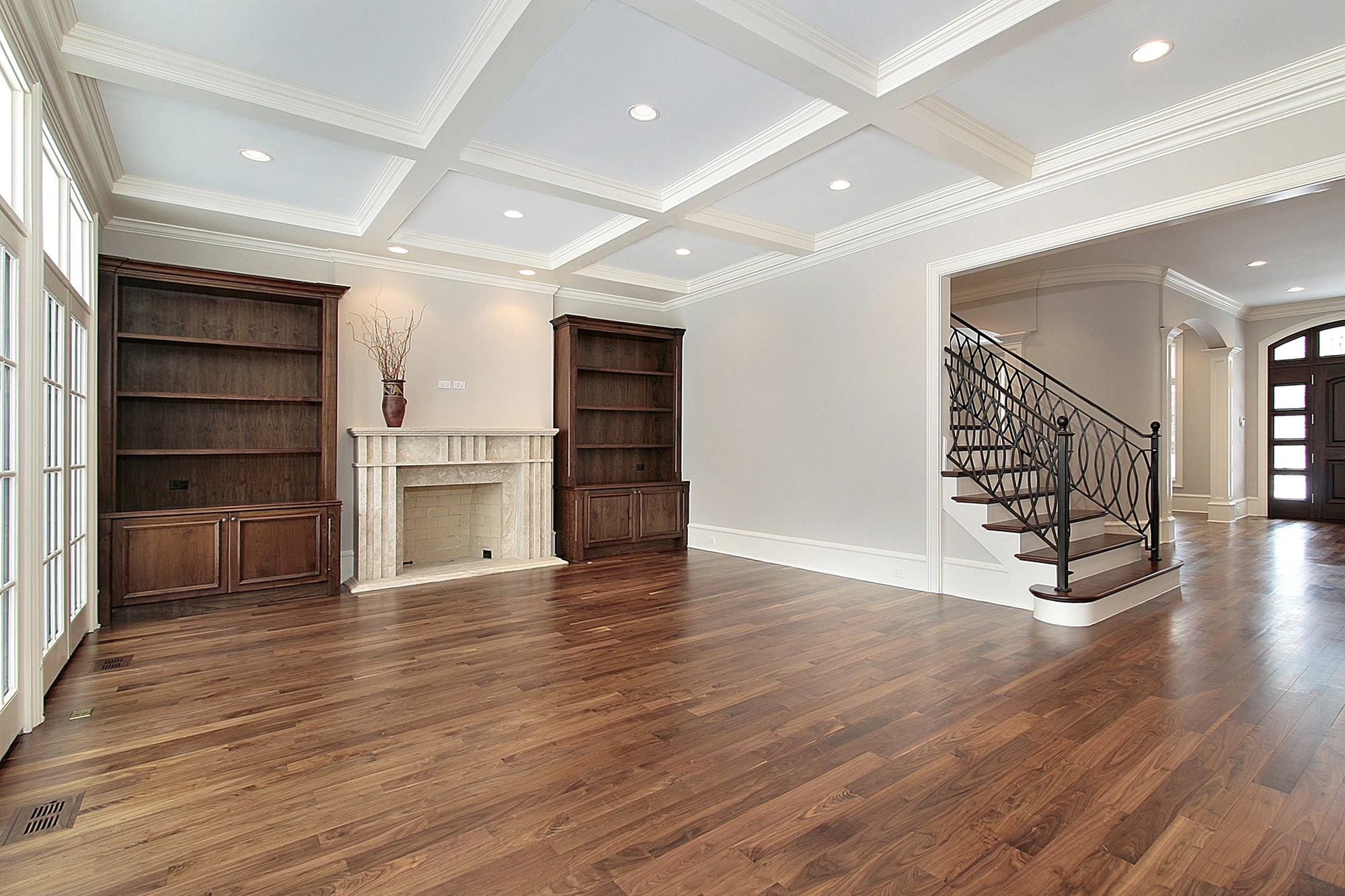 Open living room with rich brown hardwood floors and staircase